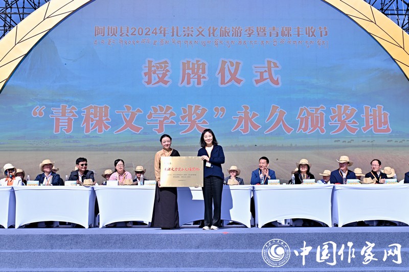 陳亞軍主編代表《民族文學(xué)》向阿壩縣授牌，紅梅部長(zhǎng)接牌。