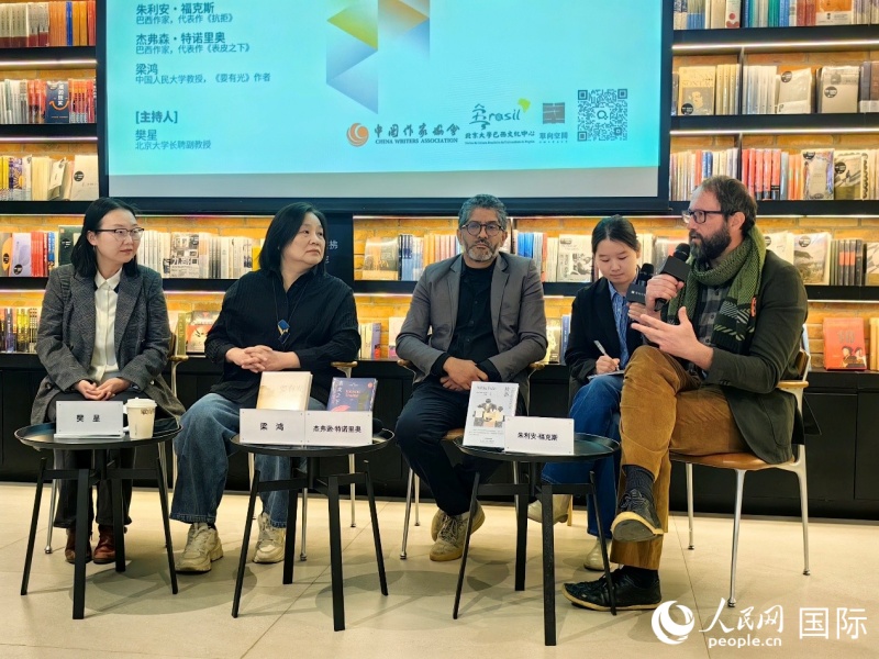 1月10日，巴西作家朱利安·?？怂梗ㄓ乙唬┖徒芨ドぬ刂Z里奧（左三）與中國人民大學(xué)教授、作家梁鴻（左二）展開對(duì)話。人民網(wǎng)記者 符園園攝